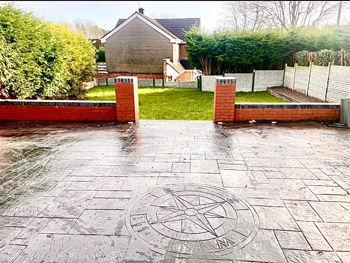 Decorative compass rose feature set in imprinted concrete driveway by Toor Concrete Driveways